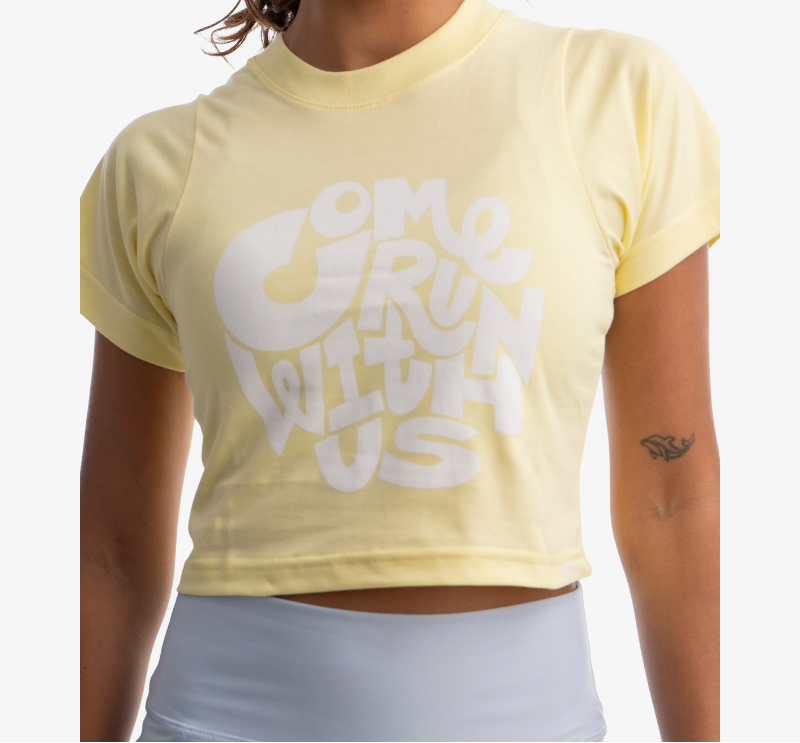 Crop top mujer color amarillo claro, vista frontal con gráfico, tela suave y ligera.