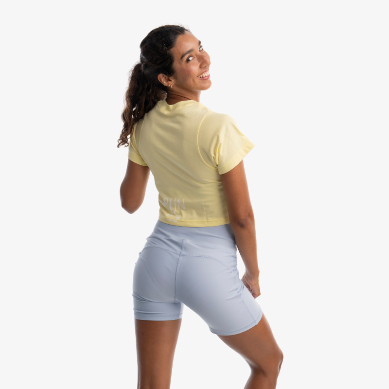 Crop top mujer color amarillo claro, vista posterior, diseño corto casual.