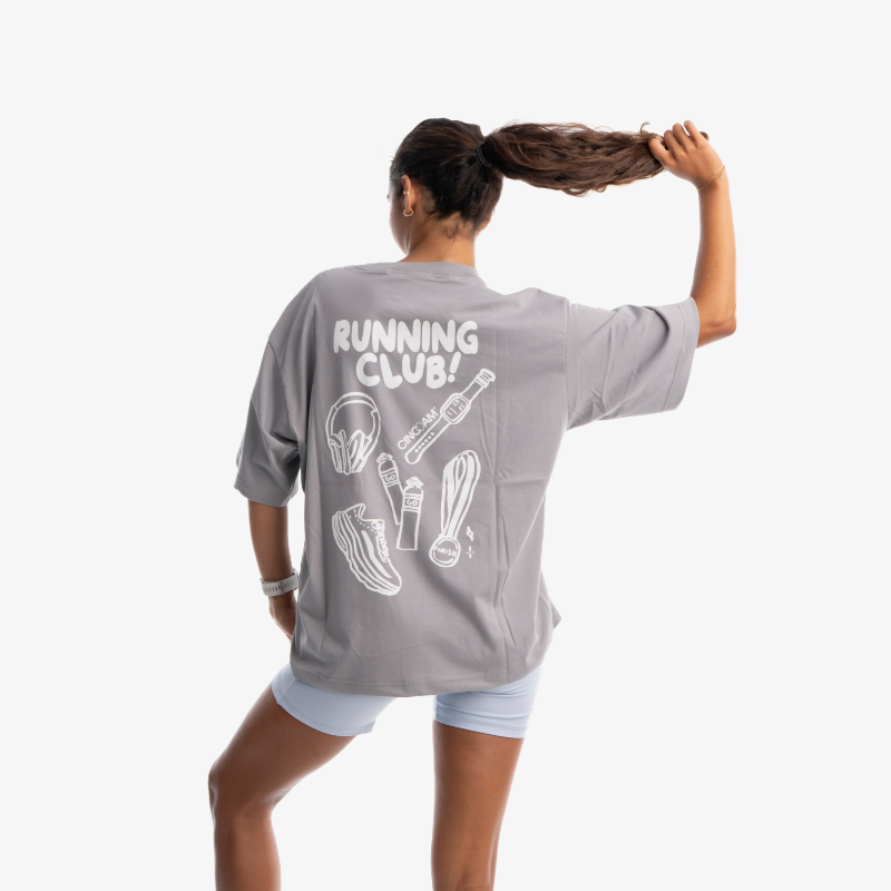 Polo mujer oversized color gris, vista posterior, diseño casual de manga corta.