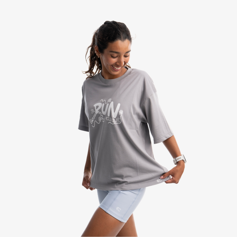 Polo mujer oversized color gris, vista posterior, diseño casual de manga corta.